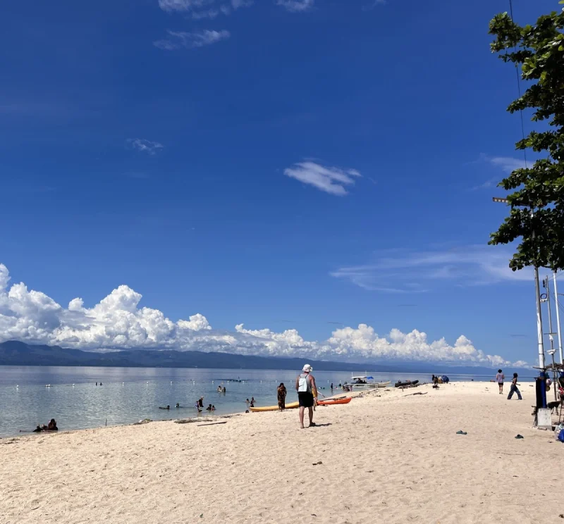 White Beach in Basdaku with palm trees and blue water